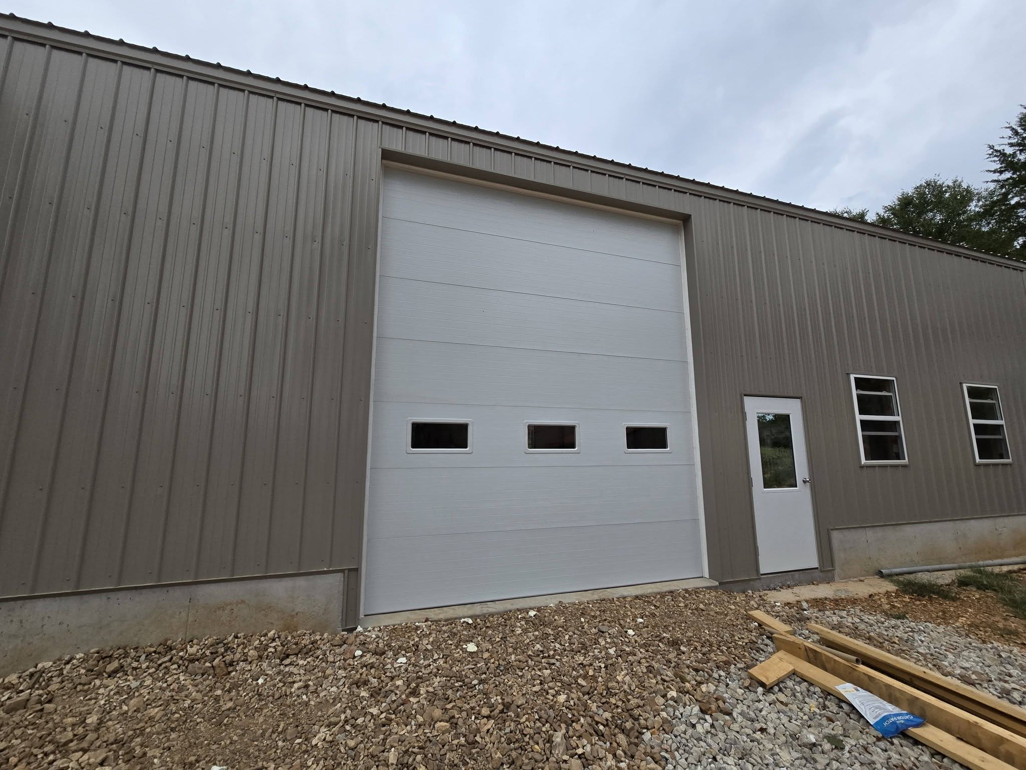 Large white overhead door installed on a metal building
